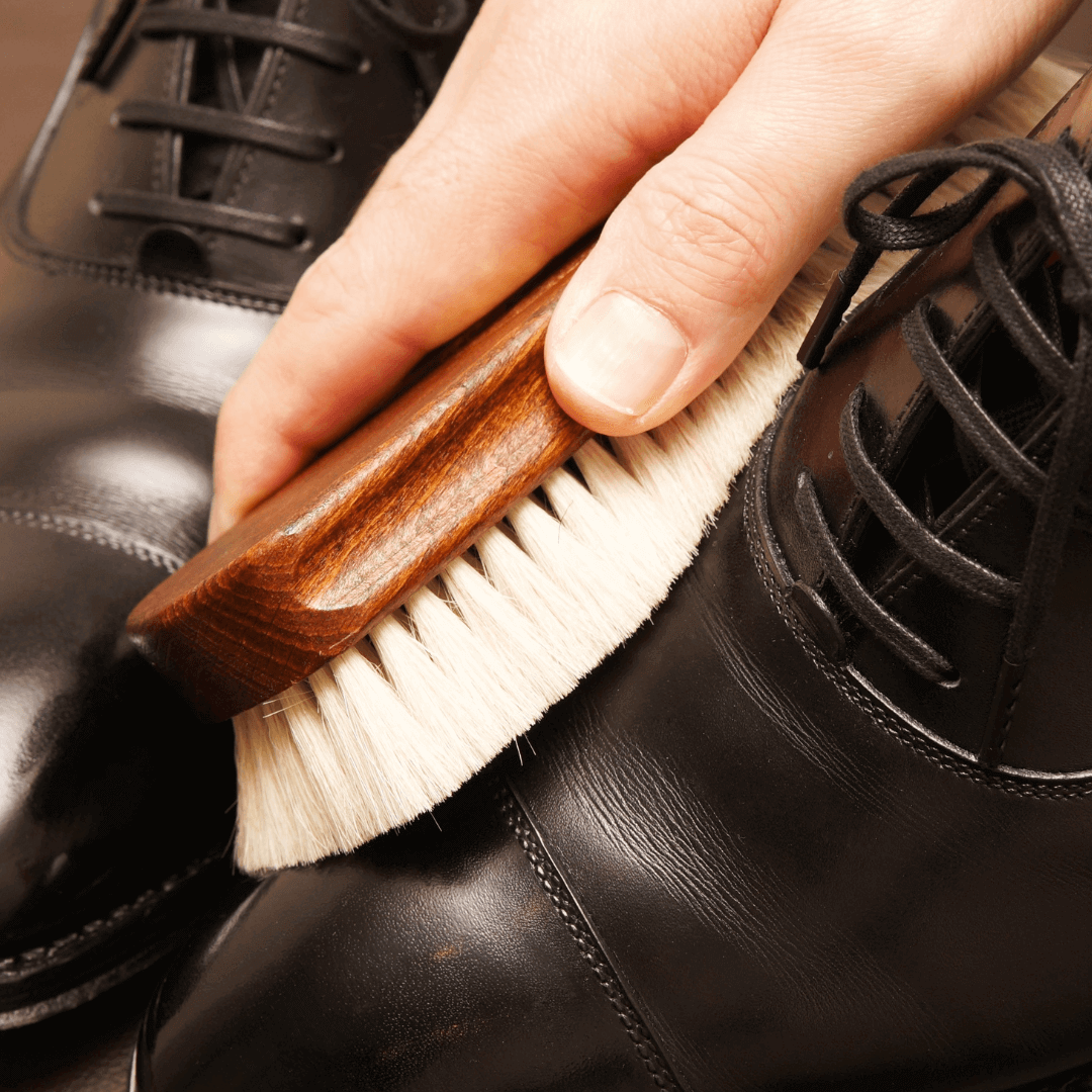 A person cleaning vegan shoes with a brush to maintain their quality and appearance. How to Clean Vegan Shoes.